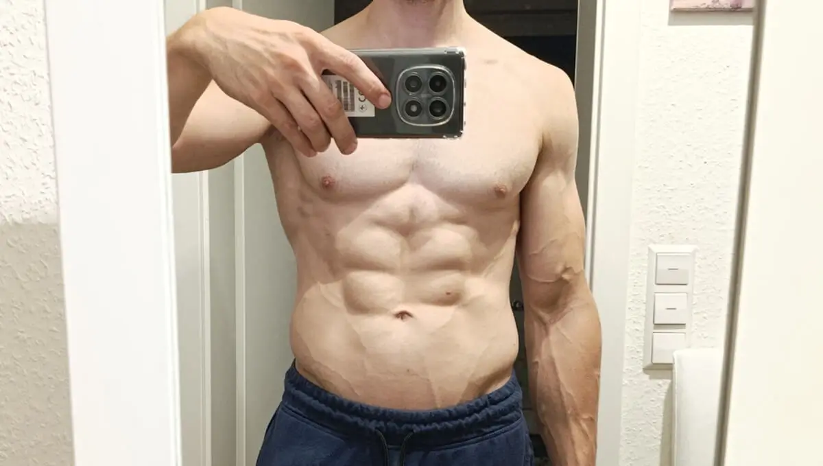 Ein Spiegel-Selfie zeigt das Sixpack von Fitness-Coach Christopher Le mit einem hohen Grad an Vaskularität, also sichtbaren Venen.